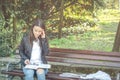 Young beautiful school or college girl with glasses sitting on the bench in the park reading the books and study for exam Royalty Free Stock Photo