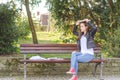 Young beautiful school or college girl with glasses sitting on the bench in the park reading the books and study for exam Royalty Free Stock Photo