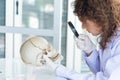 Young beautiful scientist doctor or researcher examine and study skull in laboratory