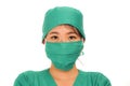 Young beautiful and serious Asian Korean medicine doctor woman or hospital nurse in medical hat surgeon face mask and green scrub Royalty Free Stock Photo