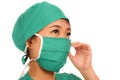 Young beautiful and serious Asian Korean medicine doctor woman or hospital nurse in medical hat surgeon face mask and green scrub Royalty Free Stock Photo