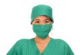 Young beautiful and serious Asian Korean medicine doctor woman or hospital nurse in medical hat surgeon face mask and green scrub Royalty Free Stock Photo