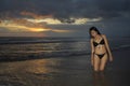 Young beautiful and asian woman in black bikini posing relaxed having fun at sunset beach in Bali island of Indonesia Royalty Free Stock Photo