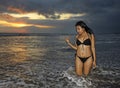 Young beautiful and asian woman in black bikini posing relaxed having fun at sunset beach in Bali island of Indonesia Royalty Free Stock Photo