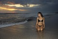 Young beautiful and asian woman in black bikini posing relaxed having fun at sunset beach in Bali island of Indonesia Royalty Free Stock Photo