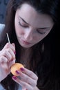 Young beautiful sexy german woman with dark hair paints a yellow Easter egg according to Sorbian tradition with a needle head and