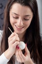 Young beautiful sexy german woman paints a white Easter egg according to Sorbian tradition with a needle head and melted wax