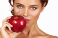 Young beautiful girl with dark curly hair, bare shoulders and neck, holding big red apple to enjoy the taste and are dieting, Royalty Free Stock Photo