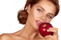 Young beautiful girl with dark curly hair, bare shoulders and neck, holding big red apple to enjoy the taste and are dieting, Royalty Free Stock Photo