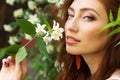 Young beautiful girl with a seductive biggest lips with long red hair sitting in the Park near the tree Jasmine Royalty Free Stock Photo