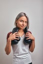 Young beautiful sexy woman boxer posing with black boxing gloves in her hands on a gray background. Copy space, gray Royalty Free Stock Photo