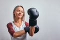 Young beautiful sexy woman boxer posing with black boxing gloves in her hands on a gray background. Copy space, gray Royalty Free Stock Photo