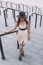 Young beautiful woman wearing trendy outfit, white dress, black hat and leather swordbelt. Longhaired brunette Royalty Free Stock Photo