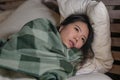 Young beautiful sick and exhausted Asian Chinese woman suffering cold and flu having temperature lying on bed covering with Royalty Free Stock Photo