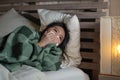 Young beautiful sick and exhausted Asian Japanese woman suffering cold and flu having temperature lying on bed covering with Royalty Free Stock Photo