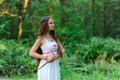 A young beautiful Slavic girl with long hair and Slavic ethnic dress stands in a summer forest with a ritual dagger in her hands Royalty Free Stock Photo