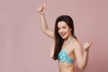 A young beautiful slender Asian girl in a blue swimsuit covered up in surprise, in admiration, in delight .  on a pink Royalty Free Stock Photo