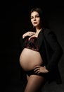 Young beautiful slim pregnant woman with long hair in posing on black background. Pregnancy motherhood, new born life expectation Royalty Free Stock Photo