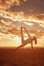 Young beautiful slim woman silhouette practices yoga on the beach at sunrise. Yoga at sunset
