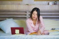 Young cute and happy nerdy Asian Korean student teenager girl in nerd glasses and hair ribbon studying at home bedroom sitting on Royalty Free Stock Photo