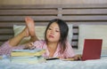 Young cute and happy nerdy Asian Korean student teenager girl in nerd glasses and hair ribbon studying at home bedroom sitting on Royalty Free Stock Photo