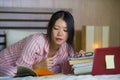 Young cute and happy nerdy Asian Korean student teenager girl in nerd glasses and hair ribbon studying at home bedroom sitting on Royalty Free Stock Photo