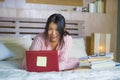 Young cute and happy nerdy Asian Korean student teenager girl in nerd glasses and hair ribbon studying at home bedroom sitting on Royalty Free Stock Photo