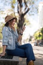 Young beautiful smiling asian woman tourist in city street using mobile phone check direction or use social media Royalty Free Stock Photo