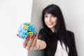 Young Beautiful smiling brunette woman dressed in black business suit holding a globe of the planet Earth