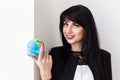 Young Beautiful smiling brunette woman dressed in black business suit holding a globe of the planet Earth. Travel concept Royalty Free Stock Photo