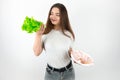 Young beautiful smiling brunette woman holding fresh salad in one hand and plate with ham in another looks happy healthy lifestyle Royalty Free Stock Photo