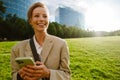 Young beautiful smiling business woman holding phone and looking aside Royalty Free Stock Photo