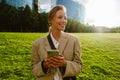 Young beautiful smiling business woman holding phone and looking aside Royalty Free Stock Photo