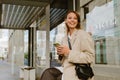 Young beautiful smiling business woman holding phone and looking aside Royalty Free Stock Photo