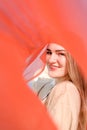 Young beautiful smiling caucasian blond woman, with minimal makeup, in light dress and red thin scarf against blue sky Royalty Free Stock Photo