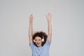 Young beautiful smiling curly woman in headphones with raised arms Royalty Free Stock Photo