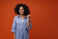 Young beautiful smiling curly woman pointing aside with thumb finger Royalty Free Stock Photo