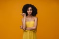 Young beautiful smiling curly woman pointing aside with thumb finger Royalty Free Stock Photo