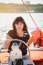 Young beautiful smiling girl in dress sailing luxury yacht in sea with walkie-talkie in hands, sunset Royalty Free Stock Photo