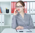 Young beautiful smiling girl talking on the mobile phone in the office. Royalty Free Stock Photo