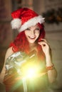 Young beautiful smiling santa woman. Christmas Fashionable luxury girl celebrating New Year holding gift Royalty Free Stock Photo