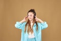 A young beautiful smiling teenage girl listens to music in black headphones and holds her hands to the headphones Royalty Free Stock Photo