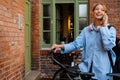 Young beautiful smiling woman with bicycle talking phone looking aside Royalty Free Stock Photo