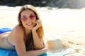 Young beautiful smiling woman enjoying relax lying on the beach looking at camera. Summer holidays concept Royalty Free Stock Photo