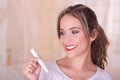 Young beautiful smiling woman holding a menstruation cotton tampon in her hand, in a blurred background