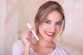 Young beautiful smiling woman holding a menstruation cotton tampon in her hand, in a blurred background Royalty Free Stock Photo