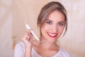 Young beautiful smiling woman holding a menstruation cotton tampon in her hand, in a blurred background Royalty Free Stock Photo