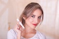 Young beautiful smiling woman holding a menstruation cotton tampon in her hand, in a blurred background Royalty Free Stock Photo