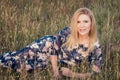 Young beautiful smiling woman lying on grass in long evening dress Royalty Free Stock Photo