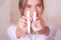 Young beautiful smiling woman pointing in front of her two menstruation cotton tampons in a blurred background